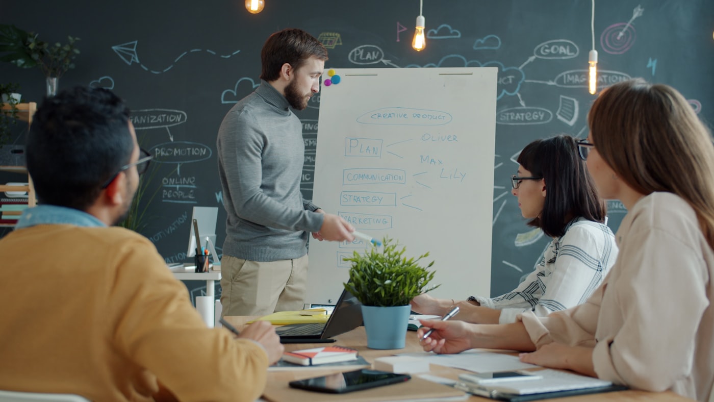 A team working through a program plan together at a whiteboard