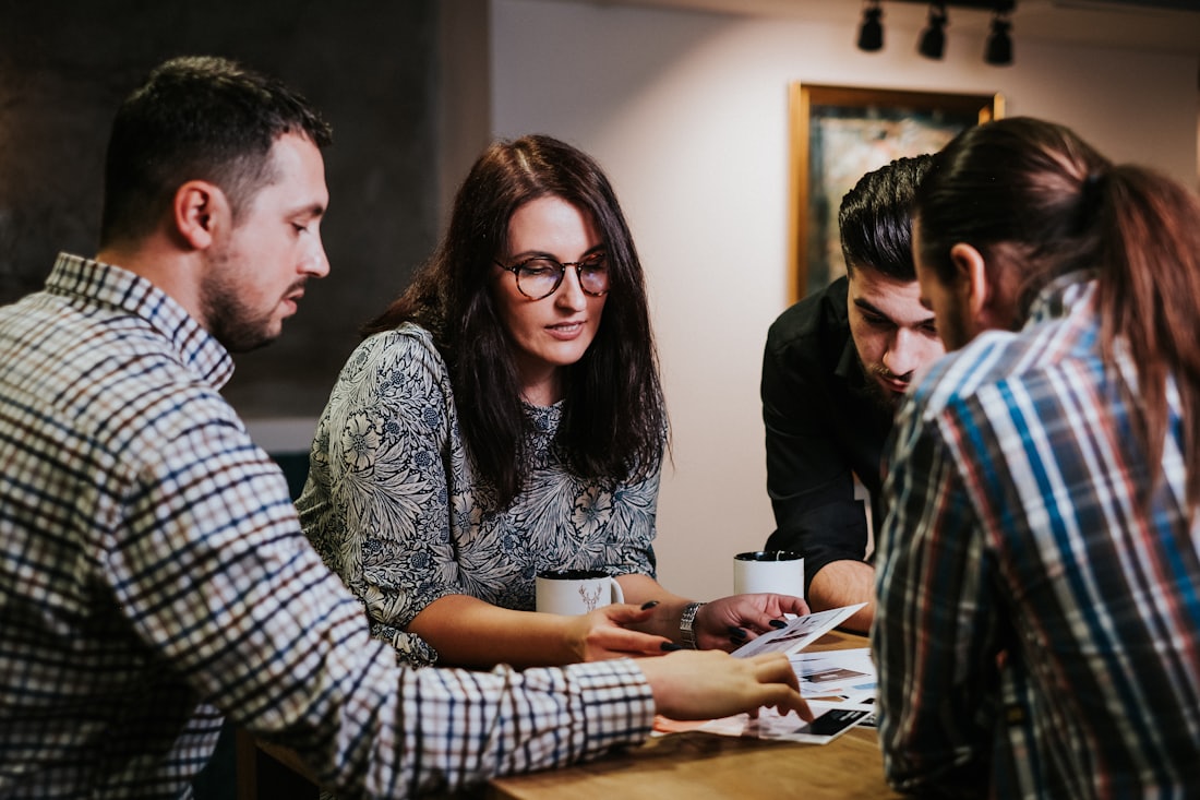 Four people reviewing programme documents together at a table